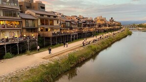 Un paseo junto al río con edificios a un lado y el río al otro.