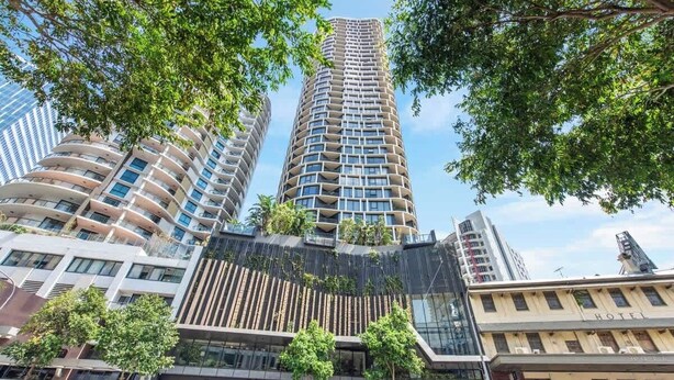 A modern hotel with a curved facade, multiple balconies, and a glass entrance. - Top Floor! 2Bed/2Bath/1Car/Pool ~ VIEWS ~ CBD (Brisbane City)