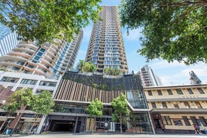 Un h ôtel moderne à la façade incurvée, doté de nombreux balcons et d’une entrée en verre.