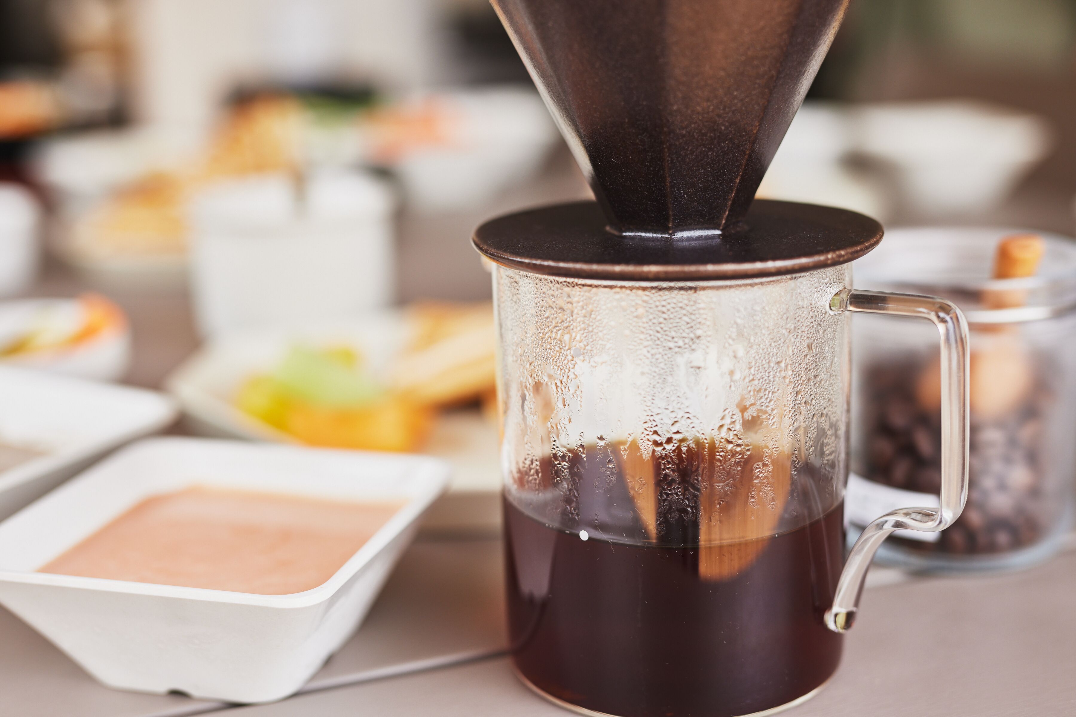 Máquina de café servindo café em uma caneca de vidro.