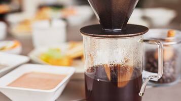 Máquina de café servindo café em uma caneca de vidro.