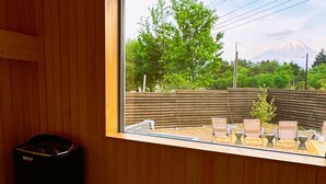 A room with a window overlooking a garden with chairs and a view of a mountain. - Dots by Dot Glamping Suite 001 (Fujikawaguchiko)