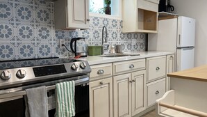 Eine moderne Küche mit einem Edelstahlbackofen, einer Kaffeemaschine und einem Kühlschrank.