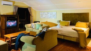 Een hotelkamer met een bed, een bank, een televisie en een bureau.