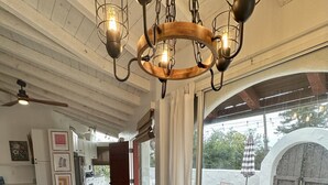 Un vaste espace de vie comprenant une table à manger en bois, un canapé et un lustre.