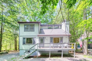 A two-story house with a covered porch and a staircase leading to the entrance.