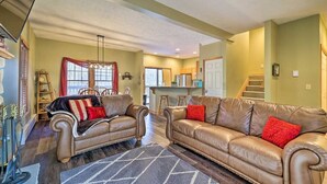 A living room with two leather sofas, a chandelier, and a kitchen in the background. - HOT TUB | 4 Min Dr to Camelbeach (Tannersville)