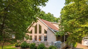 Een tweelaags huis met een veranda en een overdekt terras.