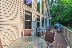 A deck with outdoor furniture, including chairs and a table, and a covered barbecue area. - Dee Grove Retreat | Game Area | Open Concept | 4 BDR Close to Skiiing, Lake (Albrightsville)