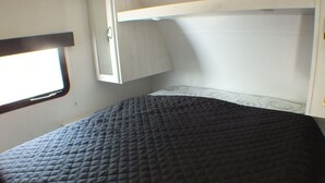 A bunk bed with a quilted mattress and a white headboard. - Koeda Village (Asahi)
