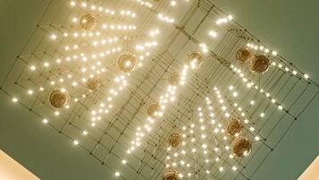 A ceiling with a grid of lights and spherical decorations.