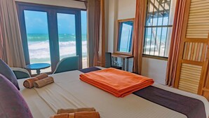 A hotel room with a bed, a desk, and a view of the beach. - Amor Beach Unawatuna (Unawatuna)