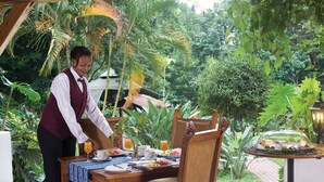 Una mesa de comedor al aire libre, atendida por un camarero.
