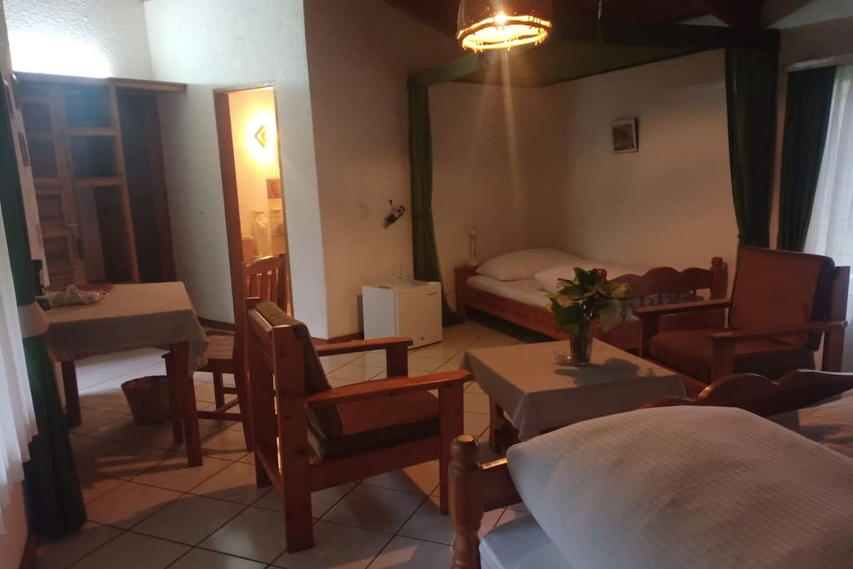 A cozy room with a bed, a desk, a chair, and a small table.