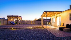 A covered outdoor patio area with seating and string lights.
