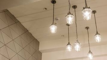 A ceiling with multiple hanging light fixtures and a tiled wall.