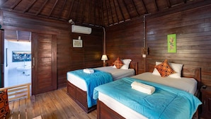 Una habitación de madera con dos camas, piso de madera y vistas al exterior.
