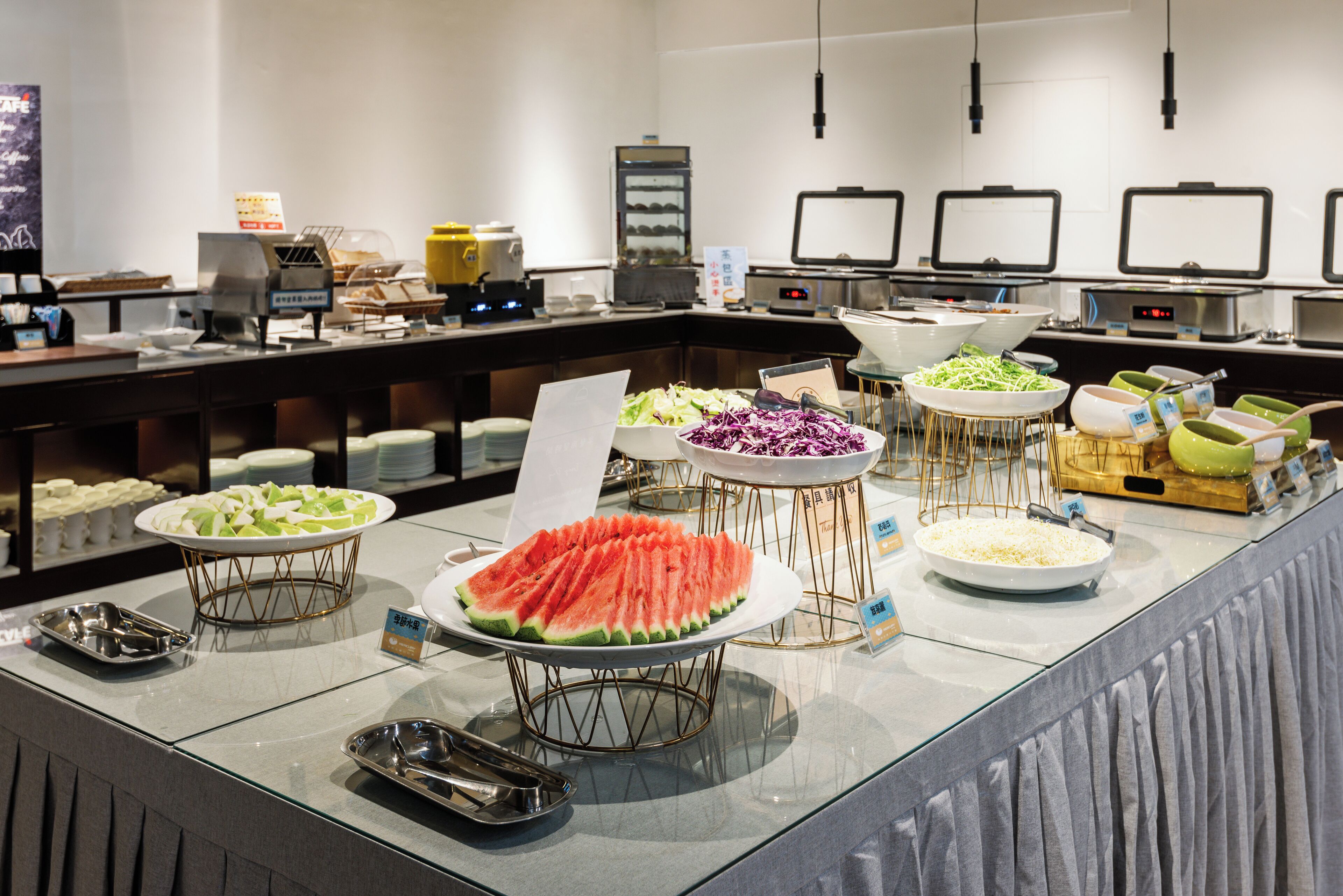 A buffet with various food items including watermelon, salad, and other dishes.