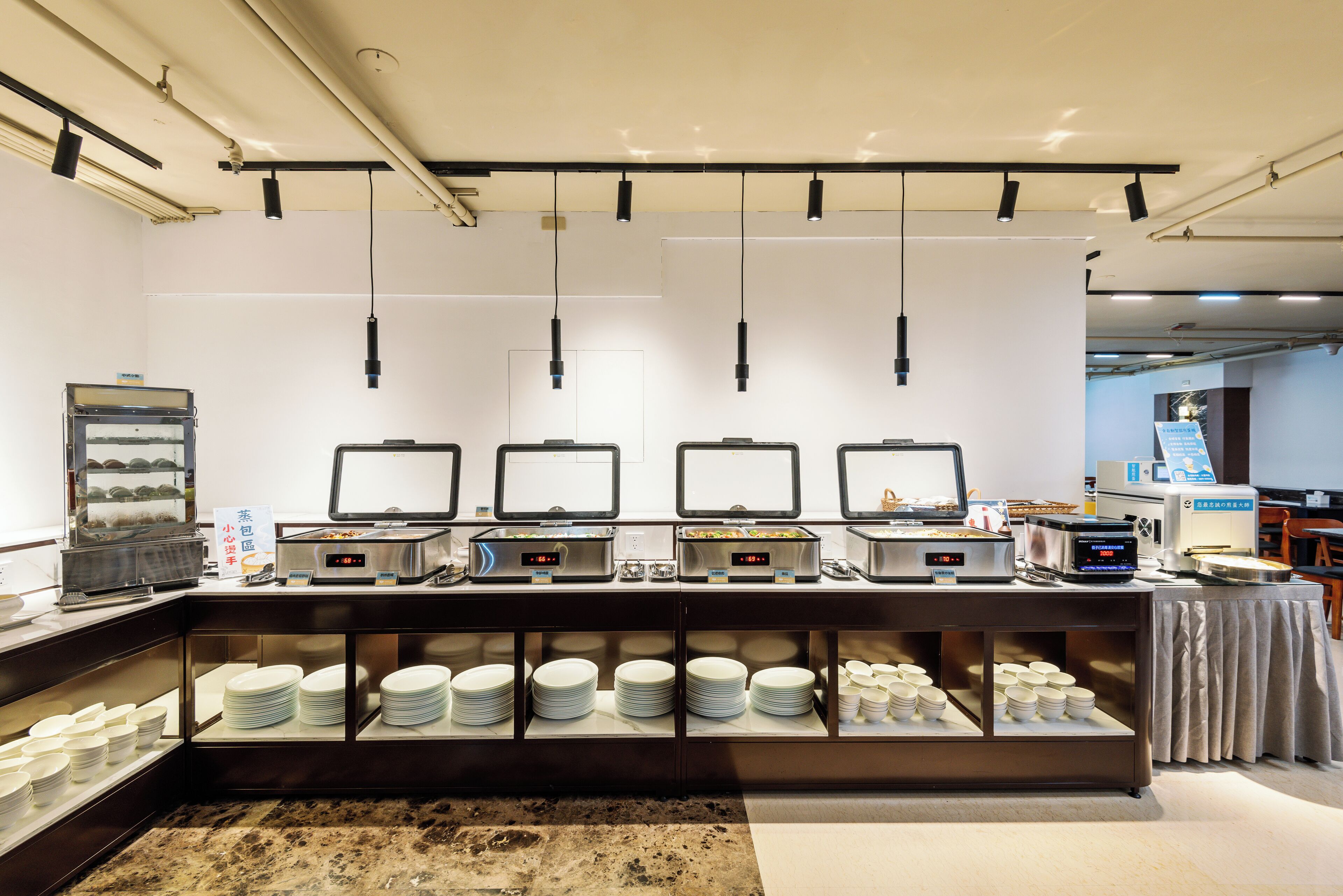 A buffet area with multiple self-service stations, each equipped with a digital display and a variety of dishes.
