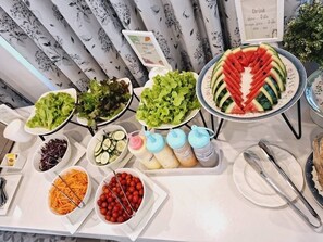 A buffet table with various food items including salads, fruits, and beverages. - Huern Kan Thong Hotel (Phrae)