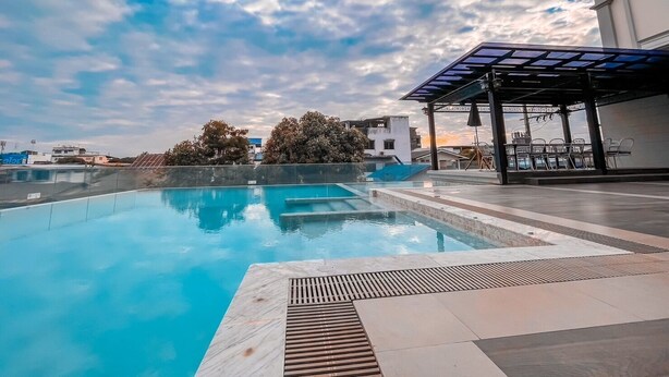 Una piscina infinita en la azotea con una vista despejada del cielo y edificios circundantes.
