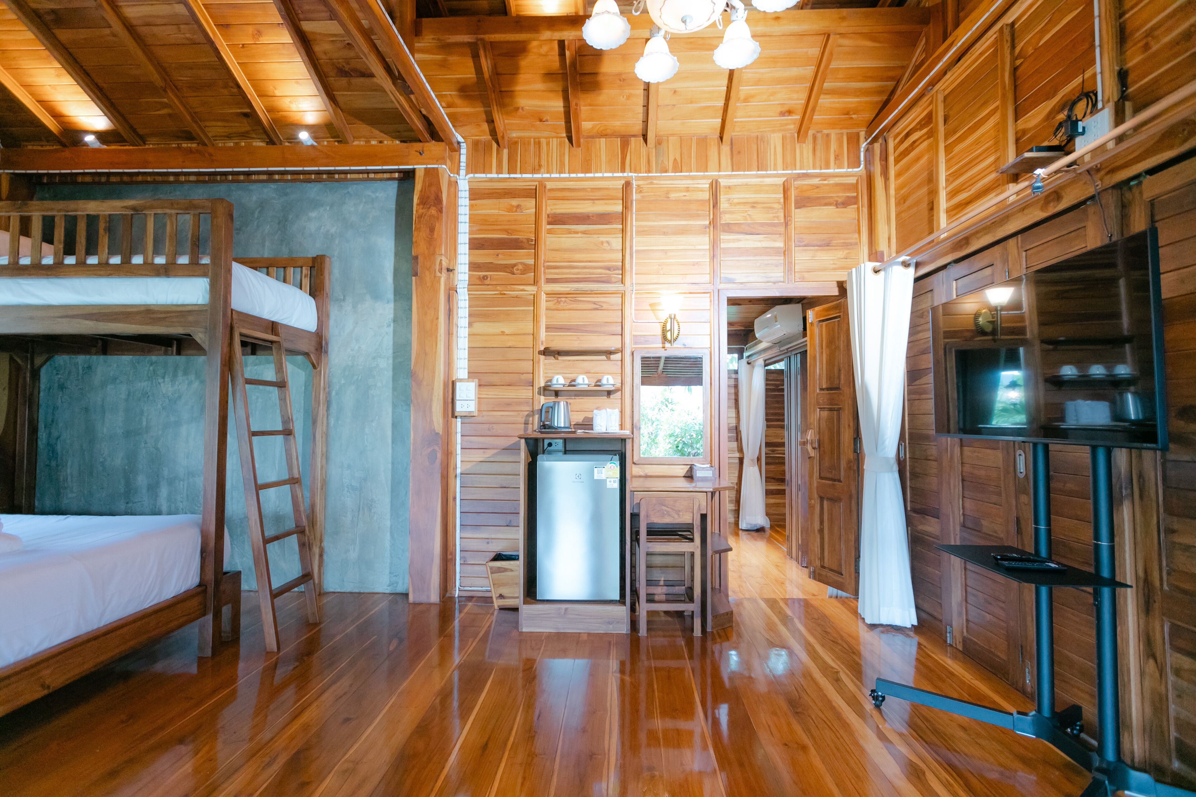 Ein Holzblockhaus-Innenraum mit Etagenbett, Küchenzeile und einer kleinen Essecke.