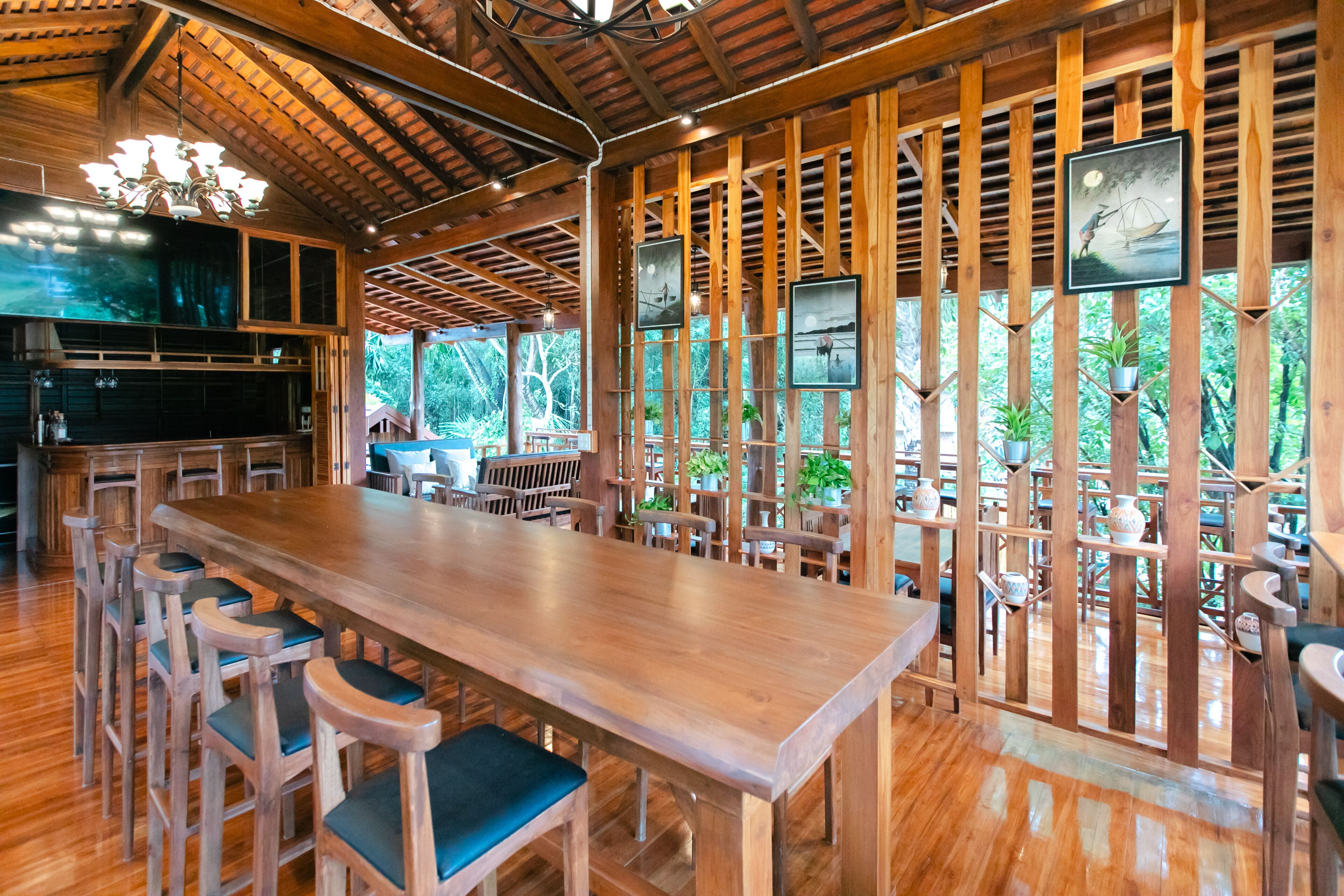 A wooden dining area with high ceilings and a large table surrounded by chairs.
