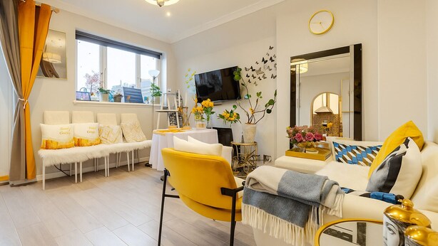 Una sala de estar moderna con un sofá, sillones, una mesa de centro y un televisor.