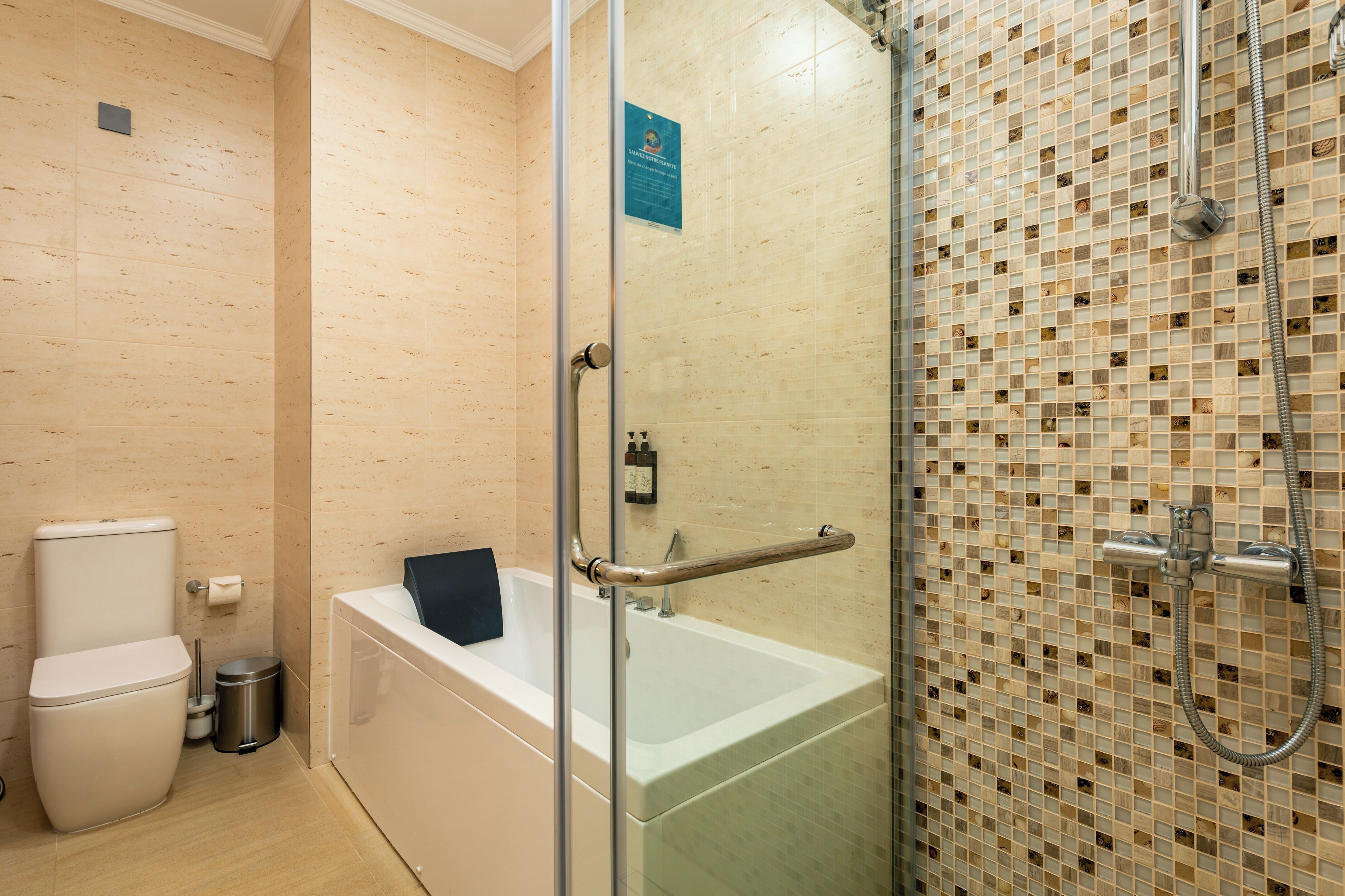 A bathroom with a glass-enclosed shower, a white bathtub, and a toilet.