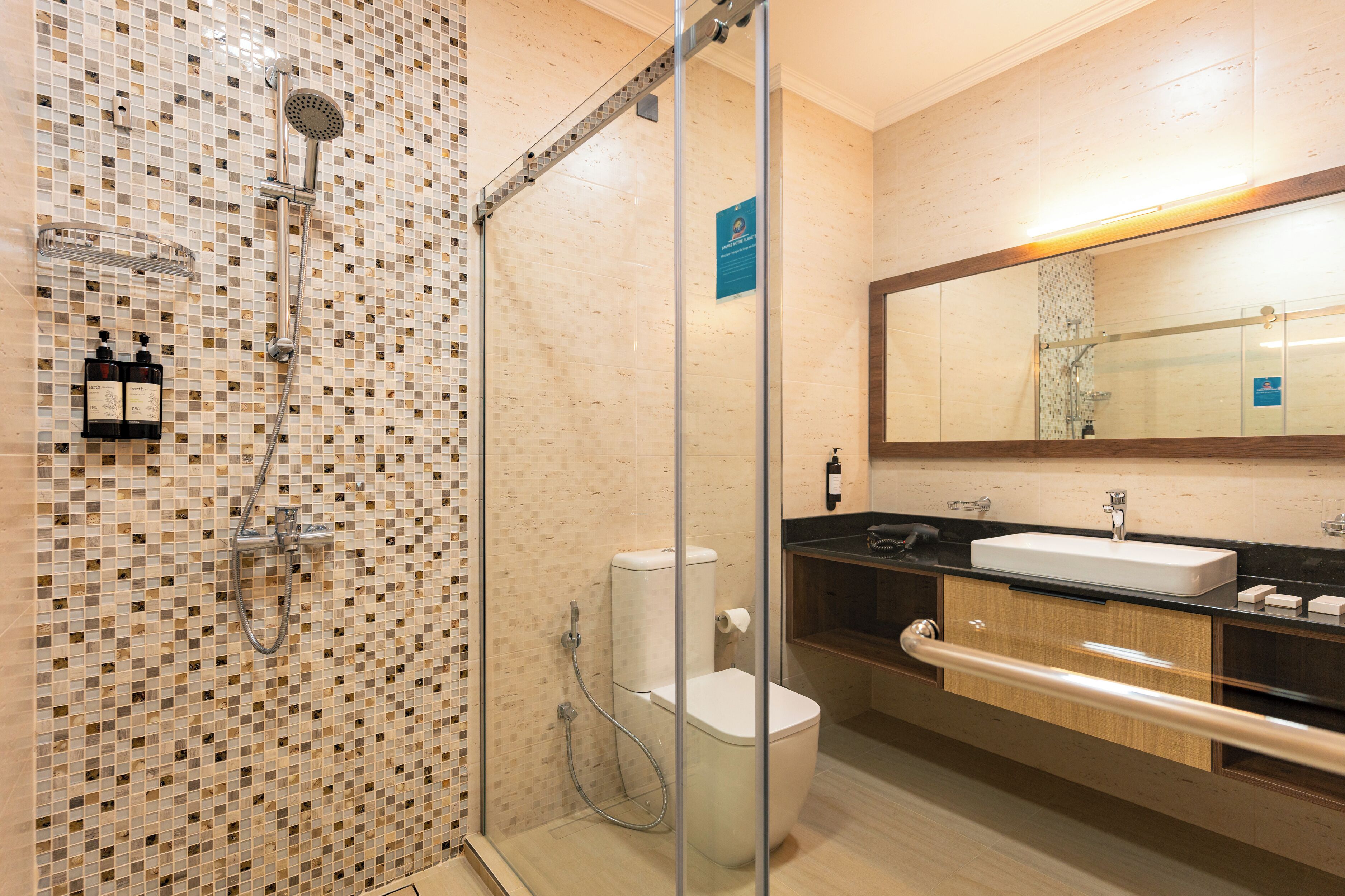 A modern bathroom with a glass-enclosed shower, a white toilet, and a black sink with a mirror above it.