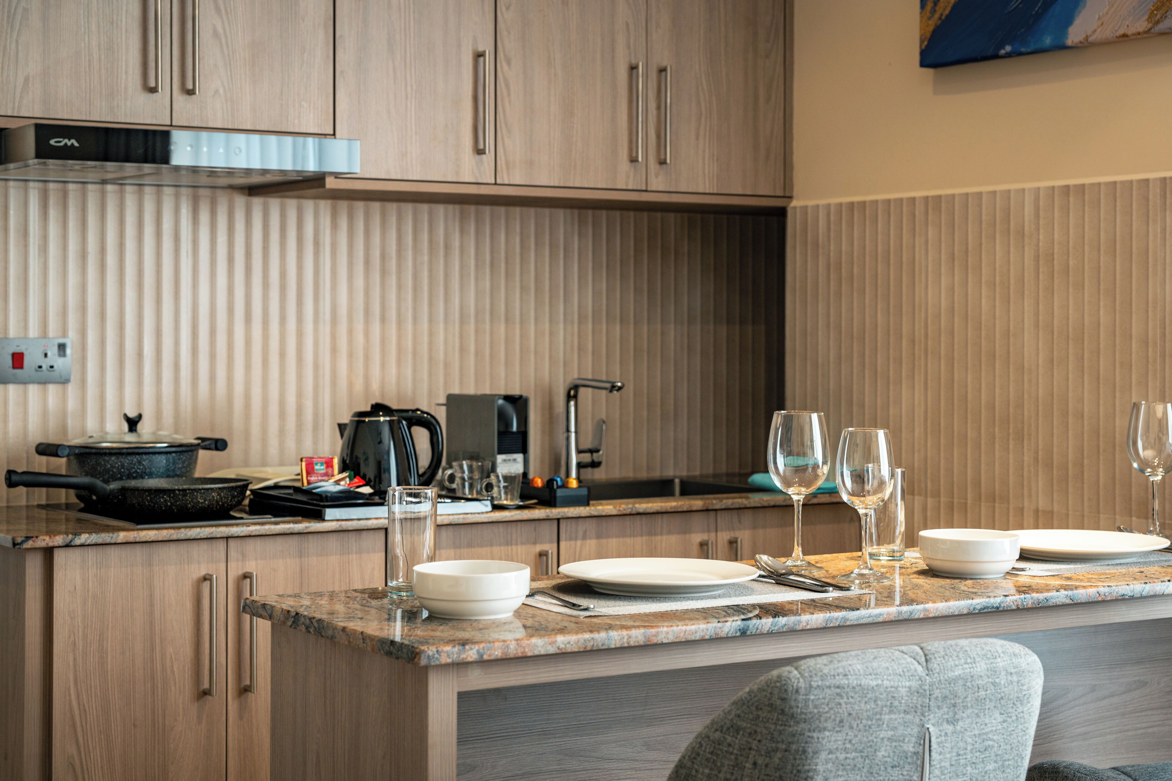 A modern kitchen with wooden cabinets, a granite countertop, and a built-in stove.
