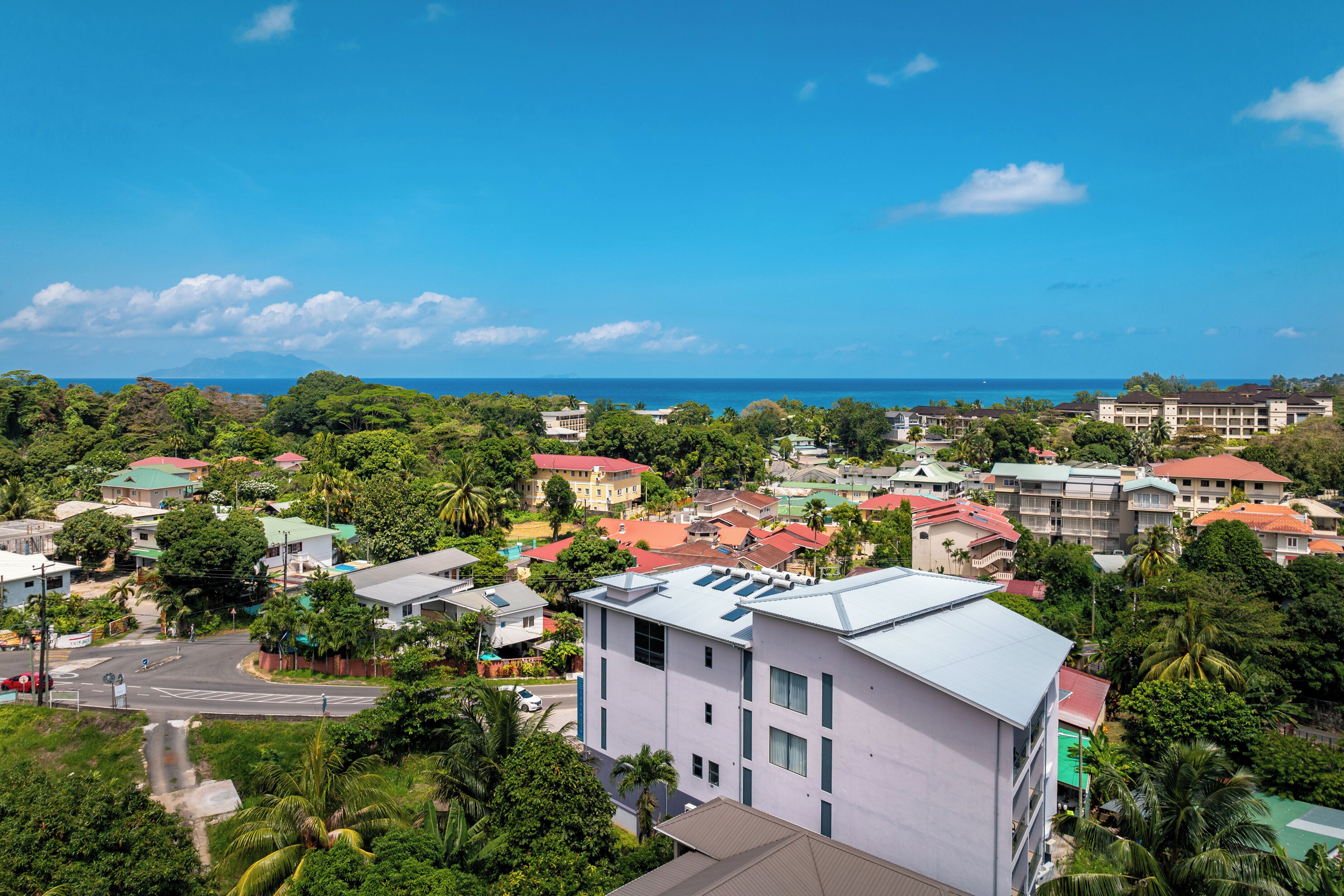 A coastal town with buildings, roads, and greenery.
