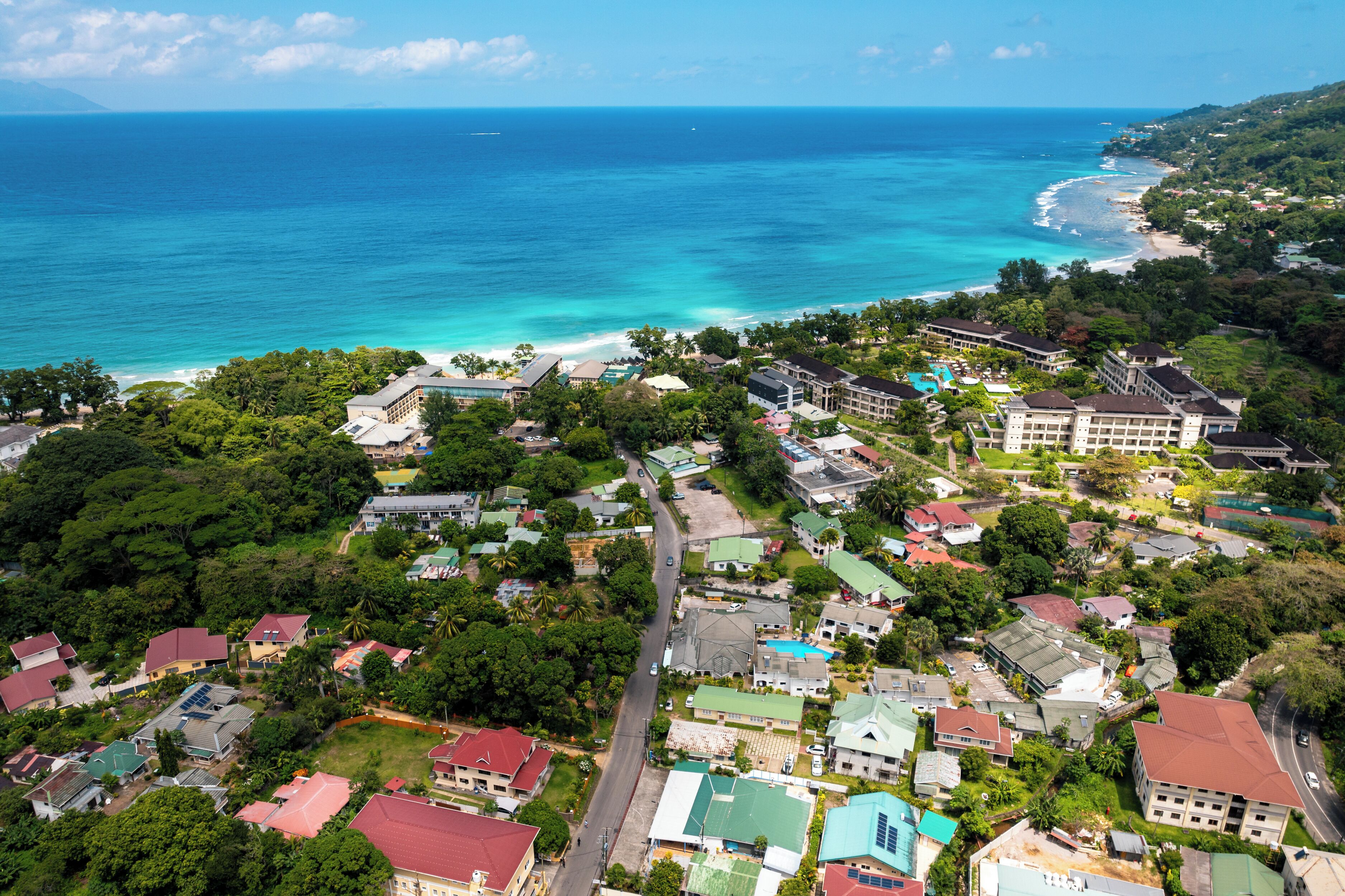 An aerial view of a coastal town with buildings, roads, and a beach.