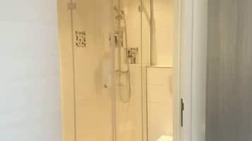 Un bagno moderno con doccia a vetro, un water e un lavandino.