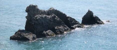 A coastal scene with rocky formations and calm sea.