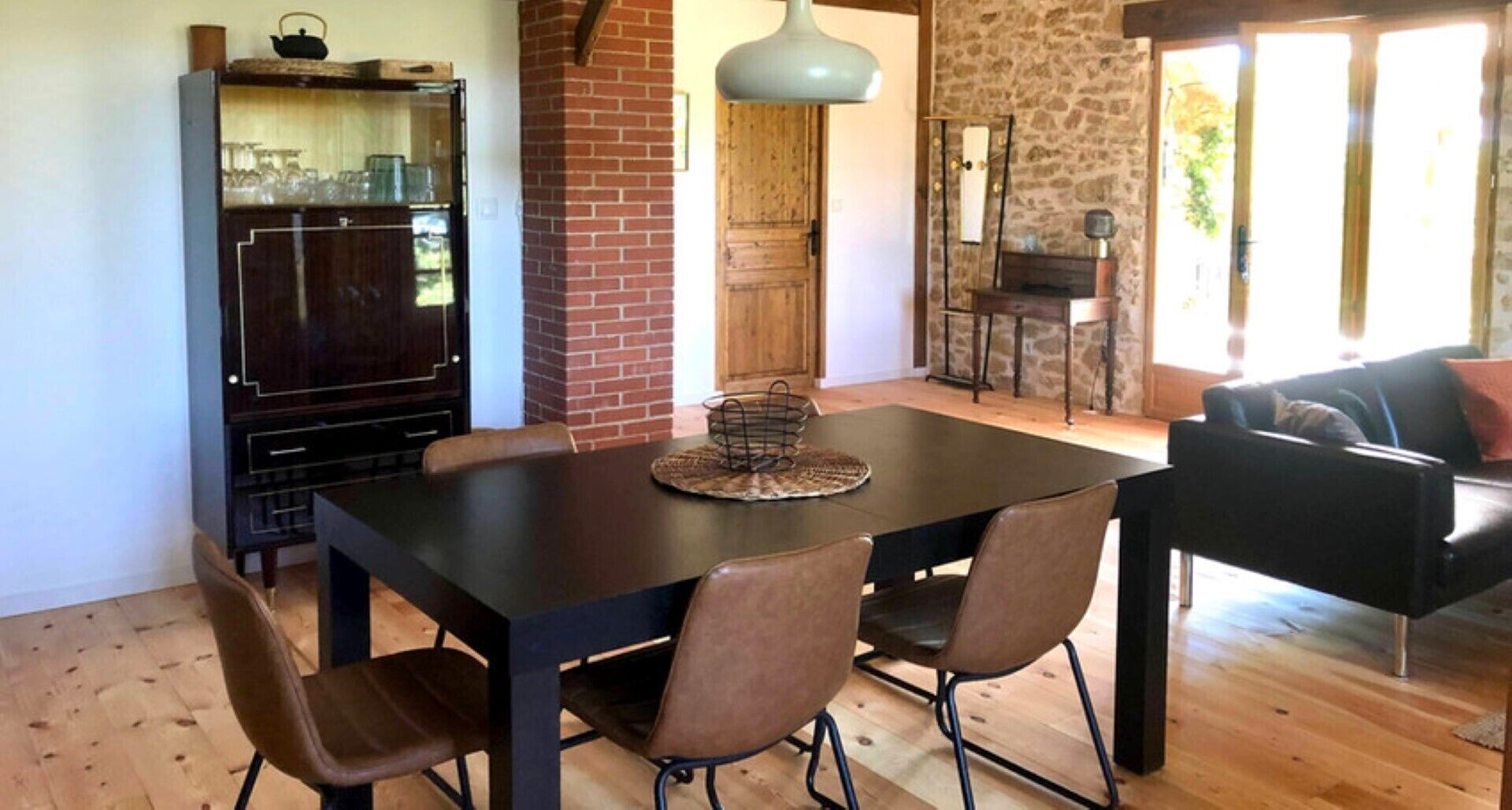 A dining area with a dark wooden table, four chairs, and a decorative centerpiece.