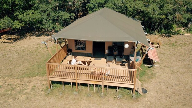A wooden deck with outdoor seating and a covered area. - Glamping Lodge Monet | Domaine du Cammazet | Pool| Comfort | Nature (Lapenne)