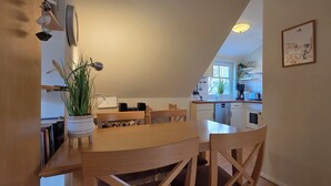 Une cuisine chaleureuse, avec des meubles en bois, une table à manger et une plante en pot.