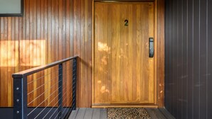 A wooden door with a number "2" above it, a metal handrail, and a patterned mat at the entrance. - The View Bright - Apartment 2 - The View Bright has a fabulous outlook and location, being one of the few places in the Bright township with uninterrupted views of the Upper Ovens Valley and Mount Bogong. (Bright)