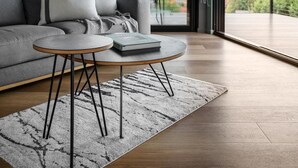 A modern living room with a grey sofa, a round coffee table, and a view of a mountainous landscape through large windows. - The View Bright - Apartment 2 - The View Bright has a fabulous outlook and location, being one of the few places in the Bright township with uninterrupted views of the Upper Ovens Valley and Mount Bogong. (Bright)