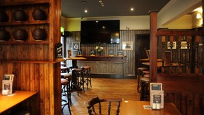 A restaurant with wooden decor, a bar area, and multiple seating options. - The Spread Eagle (Manchester)