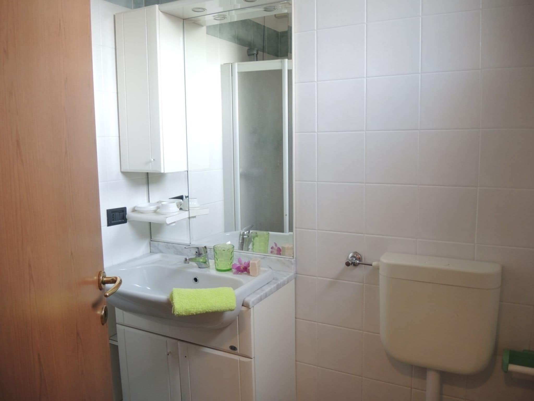 Une salle de bain avec un lavabo blanc, un miroir et des toilettes.