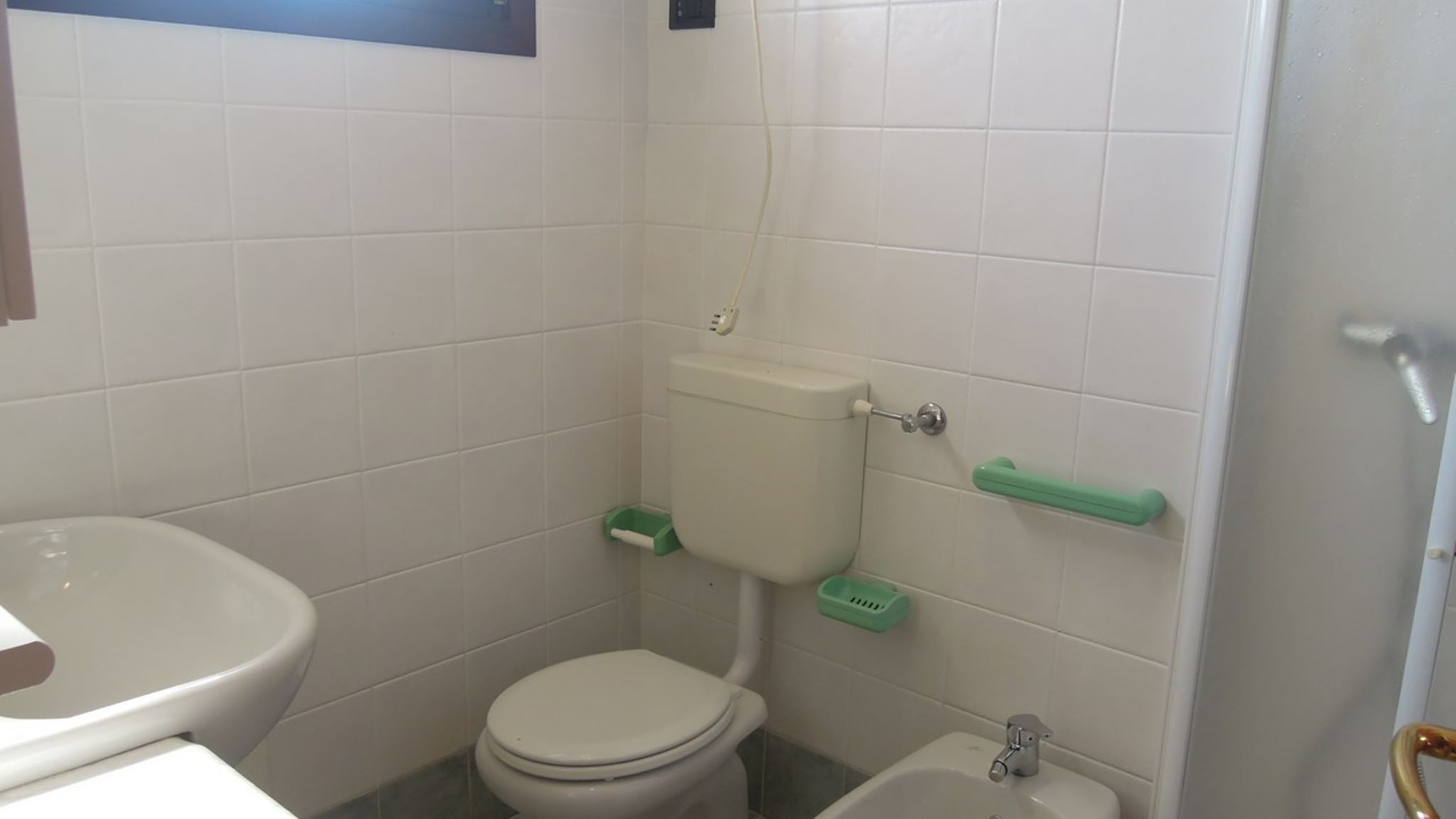 Ein kleines Badezimmer mit Toilette, Bidet und Waschbecken.