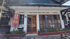 A hotel with a tiled roof, wooden door, and large windows. - Hotel Sri Timur (Yogyakarta)