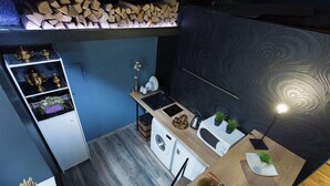 Une cuisine compacte équipée d’un lave-linge, d’un évier et d’un plan de travail agrémenté d’une plante.