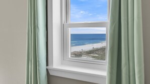 Ein Fenster mit Blick auf Strand und Meer.