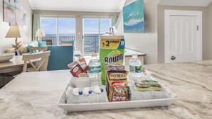 Eine Küchenarbeitsplatte mit einer Tablett voller Speisen, darunter eine Flasche Bounty Küchenpapier, eine Tüte Snyders Käse und weitere Snacks.