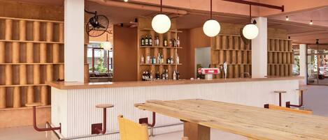 A bar area with wooden shelves, a counter, and seating.