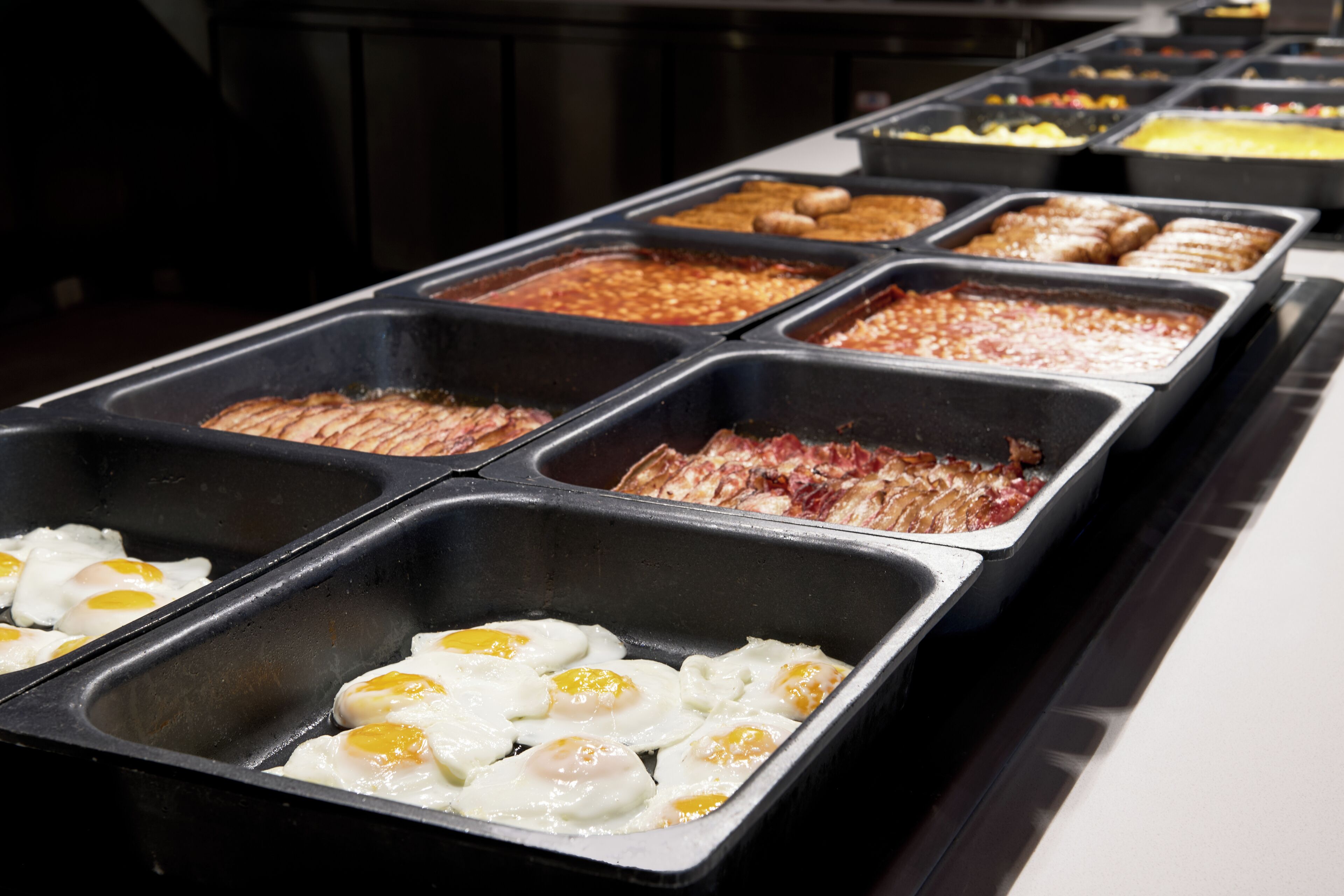A buffet with various food options including eggs, meats, and other dishes.