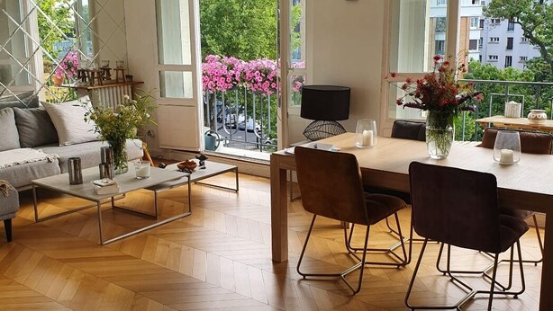 Un salon moderne comprenant un canapé, une table basse et un coin repas avec des chaises et une table.